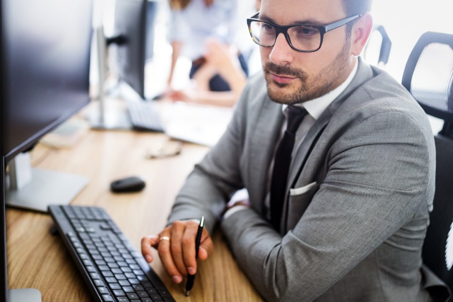 Proffessional Office Worker at Desk working on computer